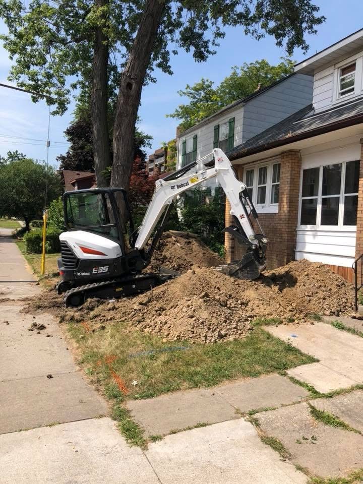Residential excavation work exposing foundation walls for drainage system installation