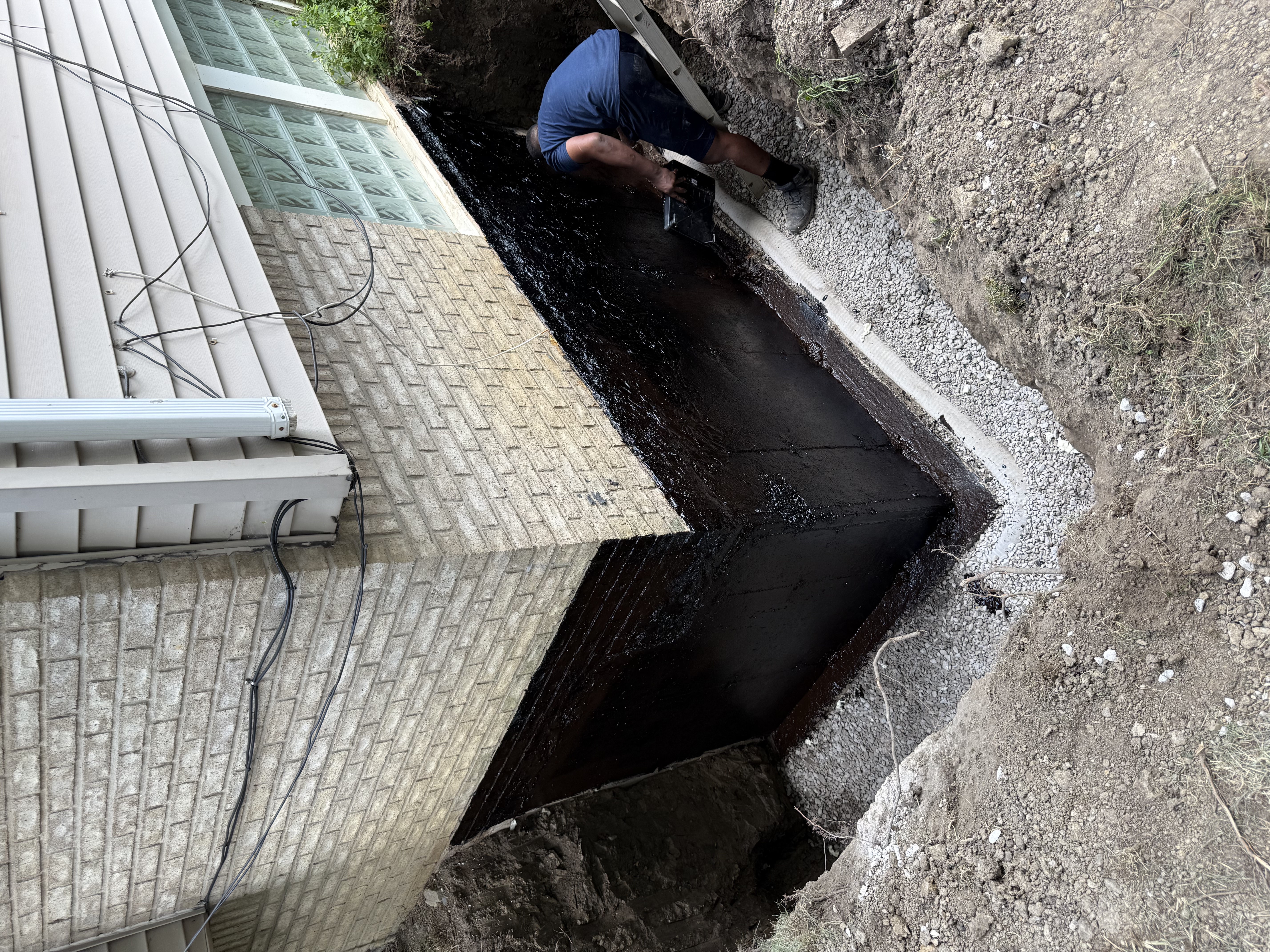 Worker applying exterior waterproofing