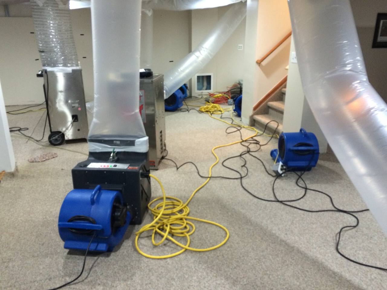 Professional basement flood restoration with water extraction equipment and emergency drying setup