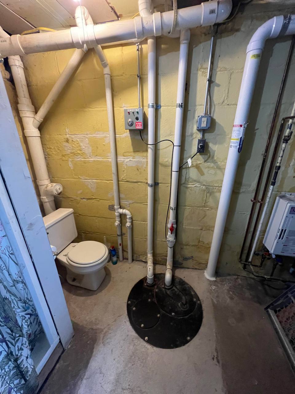 Complete sewage ejector system with pump, basin, and venting for below-grade plumbing fixtures